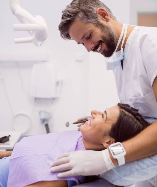 dentist-smiling-while-examining-patient